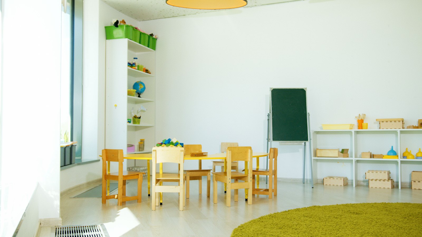 A newly set up nursery room with low shelves and soft play equipment